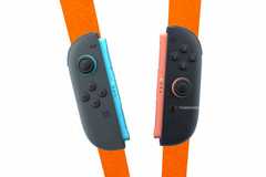 NEWS Switch 2 joy-cons over an orange background.